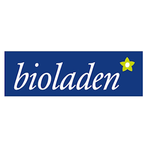 Bioladen-Logo mit weißem kursivem Text auf blauem Hintergrund und einer kleinen gelben und grünen Blume in der oberen rechten Ecke.