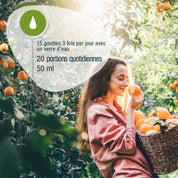 Eine Frau lächelt in einem Orangenhain, in der Hand CitroPlus® 1200 forte (Bio) FR von gse.organic.supplements. Französischer Text: dose-15 gouttes 3x/jour, 20 portions, flacon de 50 ml, riche en bioflavonoïdes.